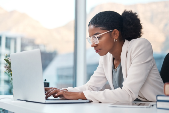 A person in an office works at a laptop