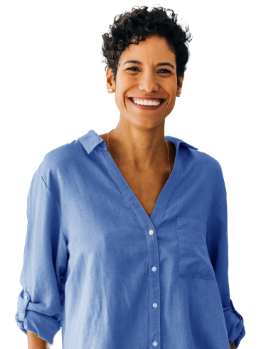 A portrait of a person with short hair smiling in a blue button up