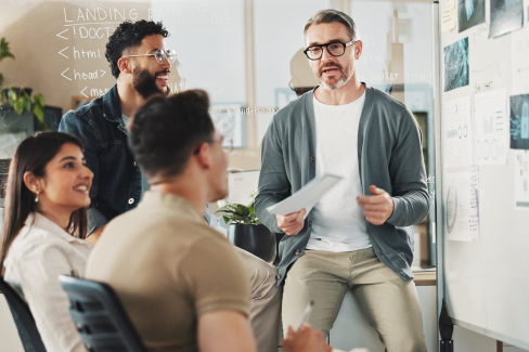 Colleagues meeting together in front of a white board