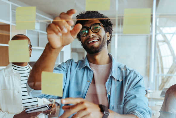 2 professionals reviewing sticky notes on a board